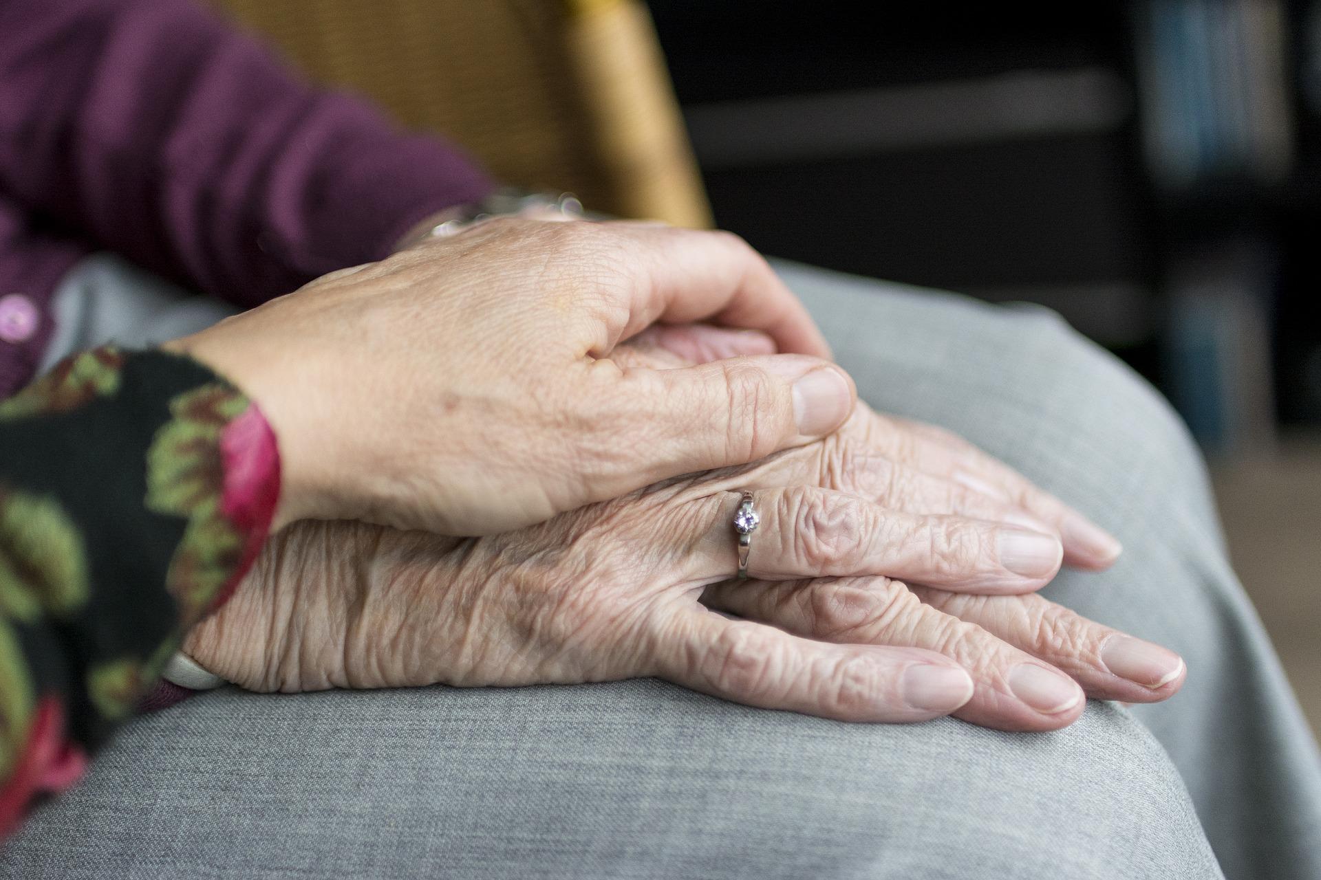 Elderly woman's hands being held by another
